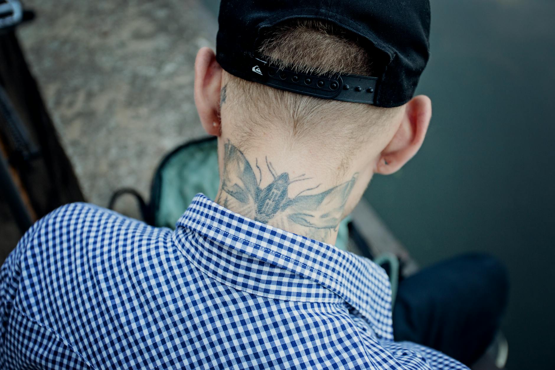 man with insect tattoo on neck